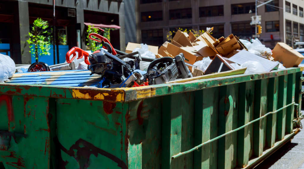 A green container dumpster loaded with garbage dumpster down a highway