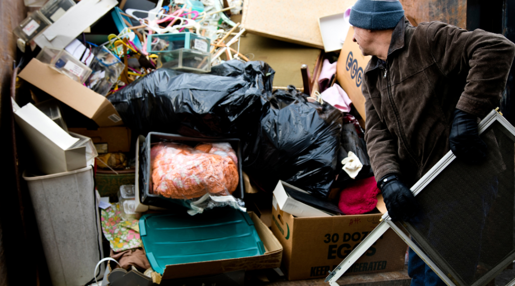 a man throwing a trash to the dumpster