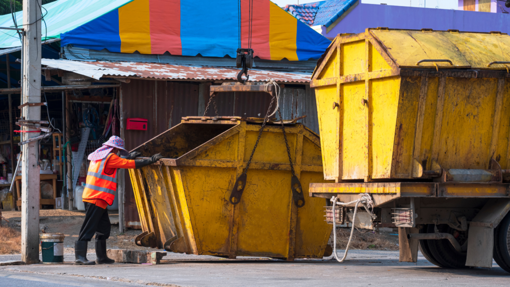 a yellow dumpster being lifted