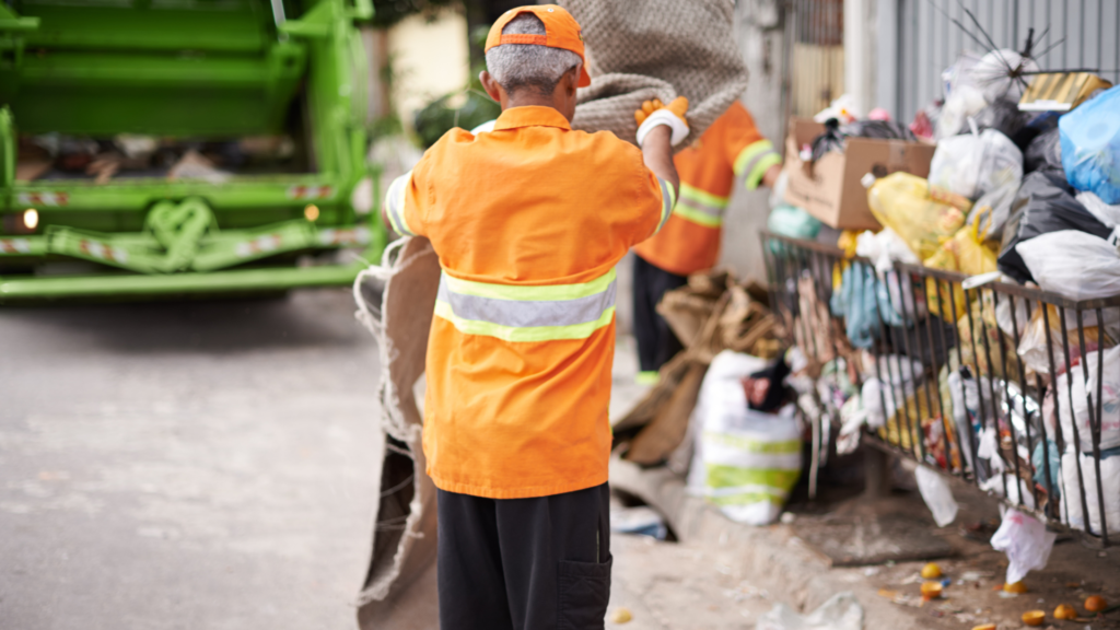 an old garbage man lifting a trash